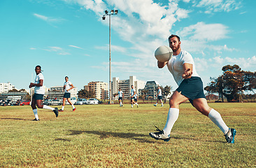 Image showing He never misses a pass. young men playing a game of rugby on a field.