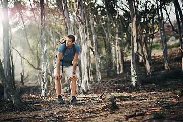 Image showing Im a bit out of breath. a carefree young man taking a quick break from hiking up a mountain during the day.