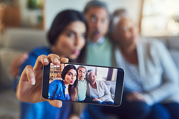 Image showing She brings so much joy into our lives. a cheerful senior couple and their daughter taking a selfie together while sitting on a couch at home.