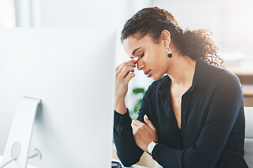 Image showing I really need to find relief from this pain. a young businesswoman looking stressed out while working in an office.