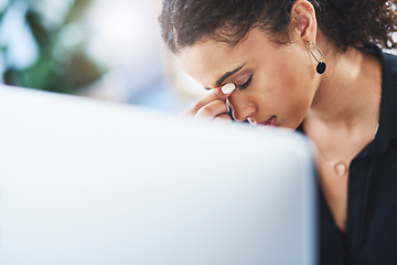 Image showing Here comes that tension headache again. a young businesswoman looking stressed out while working in an office.