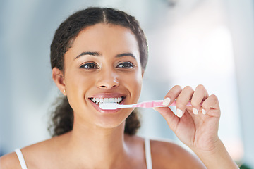 Image showing I choose to keep them shiny. an attractive young woman brushing her teeth in the bathroom at home.