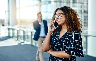 Image showing Creating happy clients is her passion. an attractive young businesswoman taking a phonecall while standing in a modern workplace.