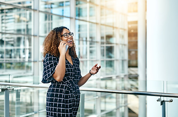 Image showing Ive been waiting to hear from you all day. an attractive young businesswoman taking a phonecall while walking through a modern workplace.