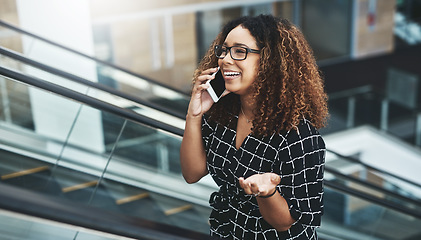 Image showing Thats a fantastic idea. an attractive young businesswoman taking a phonecall while moving up an escalator in a modern workplace.