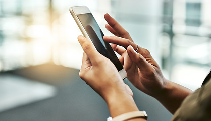 Image showing Swipe your way to success. an unrecognizable businesswoman using a smartphone while standing in a modern office.