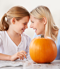 Image showing Making halloween fun. a mother and daughter carving a pumpkin together.