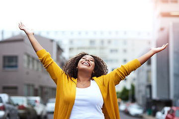 Image showing Free like a bird. a happy young woman celebrating with arms raised against a city background.