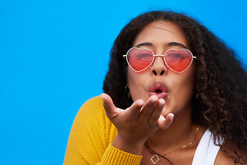 Image showing This ones especially for you. Studio portrait of an attractive young woman blowing a kiss against a blue background.