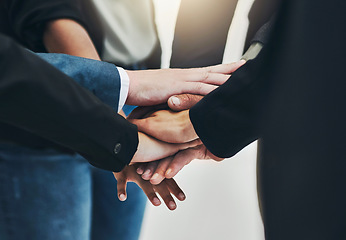 Image showing This is to our team. a group of unrecognizable businesspeople forming a huddle with their hands at work.