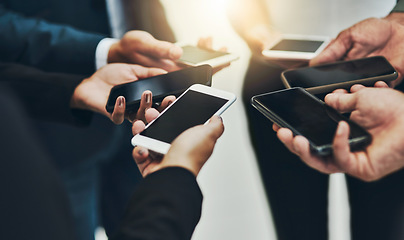 Image showing Take out your phones. a group of unrecognizable businesspeople texting on their phones at work.