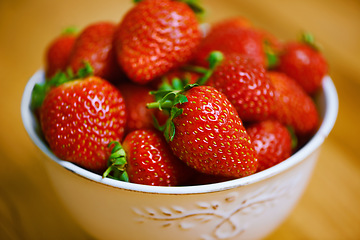 Image showing Fresh from the garden. a bowl of strawberries on a wooden table.