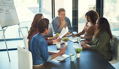 Image showing Merging their efforts towards gaining success. a group of businesspeople having a meeting in an office.