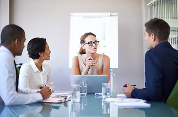 Image showing Theyre an extremely ambitious team. A group of businesspeople listening to their colleague during a meeting.