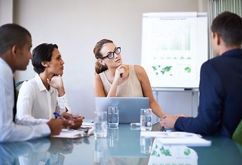 Image showing Analyzing their annual results. A group of businesspeople looking thoughtful during a meeting.