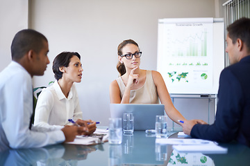 Image showing Discussing their figures for the year. A group of businesspeople having a meeting.