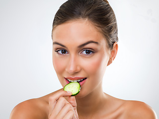 Image showing Good food wont go to waste. Portrait of a gorgeous young woman eating a slice of cucumber.
