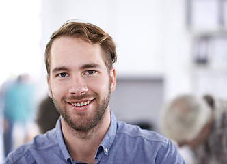 Image showing My job actually makes me happy. Portrait of a handsome young businessman with his colleagues working in the background.