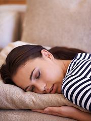 Image showing Fast asleep. an attractive young sleeping on her sofa at home.