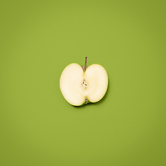 Image showing Cut into your health. a green apple against an empty studio background.