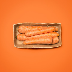 Image showing Gotta keep those eyes strong. a box of carrots against a studio background.