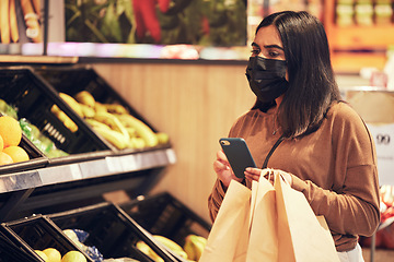 Image showing Looking for online recipes. a woman using her smartphone while doing her grocery shop.