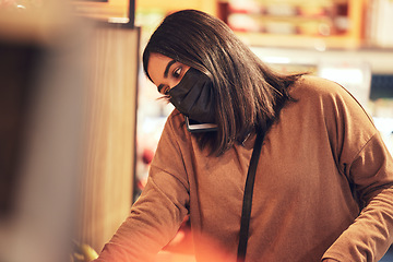 Image showing What are you craving for dinner. a young woman making a phone call while doing her grocery shop.