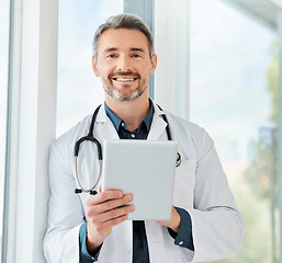 Image showing A desire to care. a mature doctor using a tablet in a office.