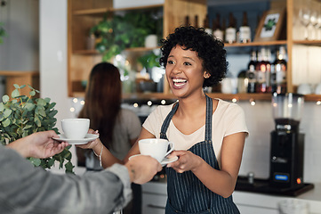 Image showing Serving quality coffee in a trendy atmosphere. a young woman serving coffee to a customer in a cafe.