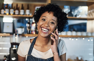 Image showing Putting in the hard work towards a profitable small business. Portrait of a young woman talking on a cellphone while working in a cafe.