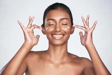 Image showing Having glowing skin is really not that hard. a beautiful woman applying moisturiser to her face.