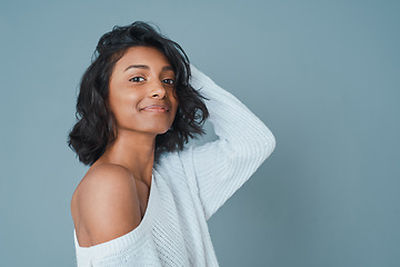 Image showing Happy looks good on you. a beautiful young woman posing against a teal background.