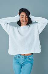 Image showing Block out the haters. a beautiful young woman posing against a teal background.