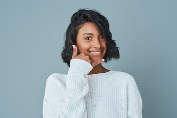 Image showing Good vibes are calling. a beautiful young woman posing against a teal background.