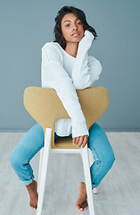 Image showing Theres power in loving yourself. a beautiful young woman sitting on a chair against a teal background.