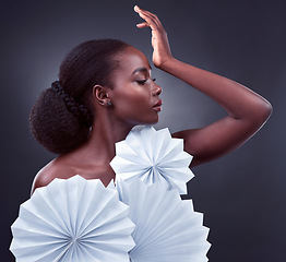 Image showing Elegance is beauty that never fades. Studio shot of a beautiful young woman posing with origami fans against a black background.