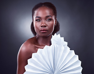 Image showing Im a big fan of natural beauty. Studio portrait of a beautiful young woman posing with origami fans against a black background.
