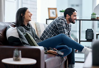 Image showing On Saturdays we watch sport. a young couple watching tv together at home.