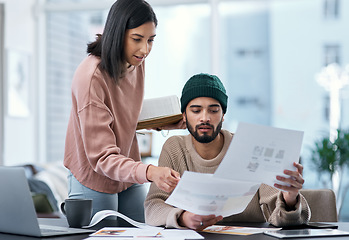 Image showing Teamwork yields the highest return in any marriage. a young man and woman using a laptop and going though paperwork while working from home.