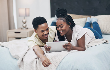 Image showing Dates can be just as fun during lockdown. a young couple using a digital tablet while relaxing on their bed at home.