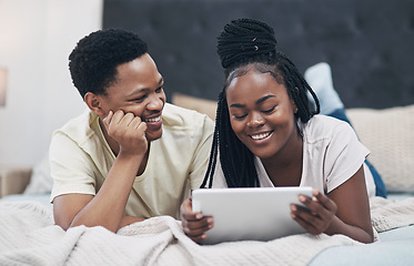 Image showing Lockdown is fun when youre with your favourite one. a young couple using a digital tablet while relaxing on their bed at home.