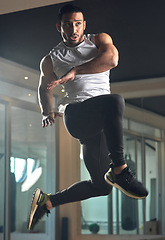 Image showing Reaching new levels. Full length shot of a handsome young male athlete jumping during his workout in the gym.