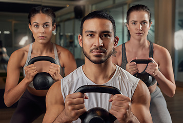 Image showing Adding some weight to their workout. Cropped portrait of three young athletes working out with kettle bells in the gym.