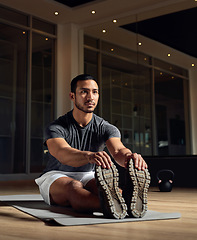 Image showing Stretching it out. Full length shot of a handsome young male athlete going through his warmup routine in the gym.