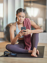 Image showing Checking her messages between sets. Full length shot of an attractive young female athlete checking her phone while sitting in the gym.