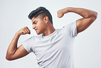 Image showing You gptta hustle for some muscle. Studio shot of a young man flexing against a white background.