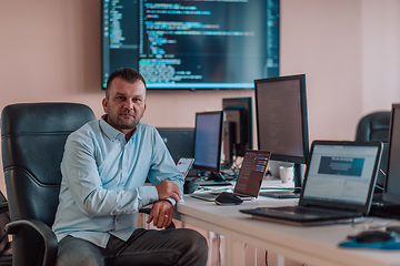 Image showing A programmer diligently testing smartphone applications while sitting in their office.