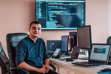 Image showing A programmer diligently testing smartphone applications while sitting in their office.