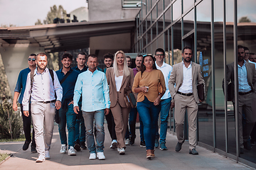 Image showing A diverse group of businessmen and colleagues walking together by their workplace, showcasing collaboration and teamwork in the company.