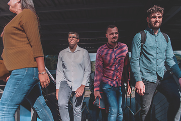 Image showing A diverse group of businessmen and colleagues walking together by their workplace, showcasing collaboration and teamwork in the company.